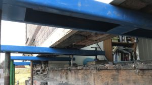 Prop Pal 1200 Needle System in use on a construction site. In this photo the Prop Pal system is being used to hold up the base of a wall that's undergoing repairs.