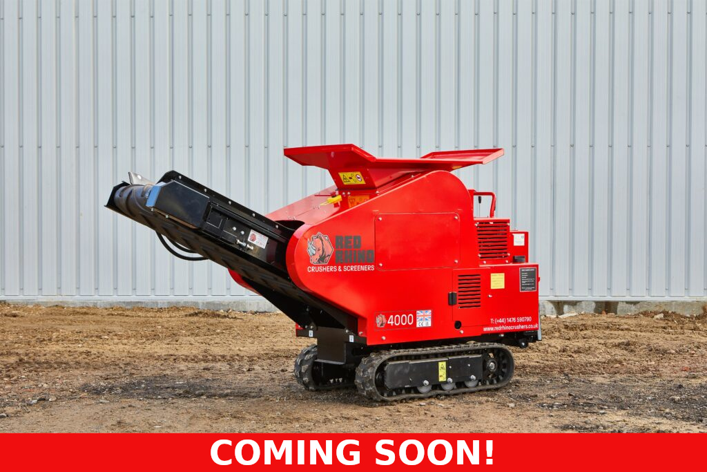 Photo of the Red Rhino 4000 Mini Crusher on some rough, sandy ground. This is a bright red piece of equipment, on caterpillar tracks. A conveyor belt can be seen on the front of the mini crusher. Across the bottom of the photo is some white text on a red background. The text says "Coming Soon!".